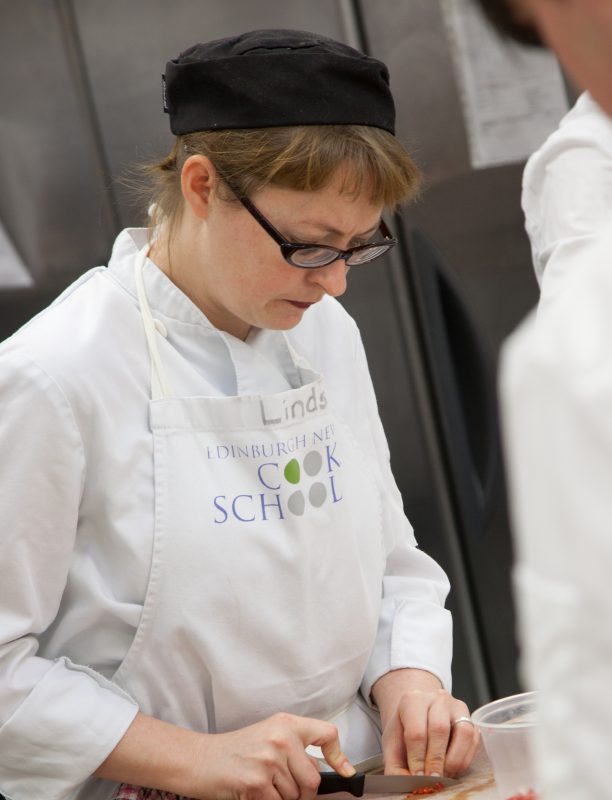 Cook school UK trainer demonstrating cooking techniques at cook school Edinburgh